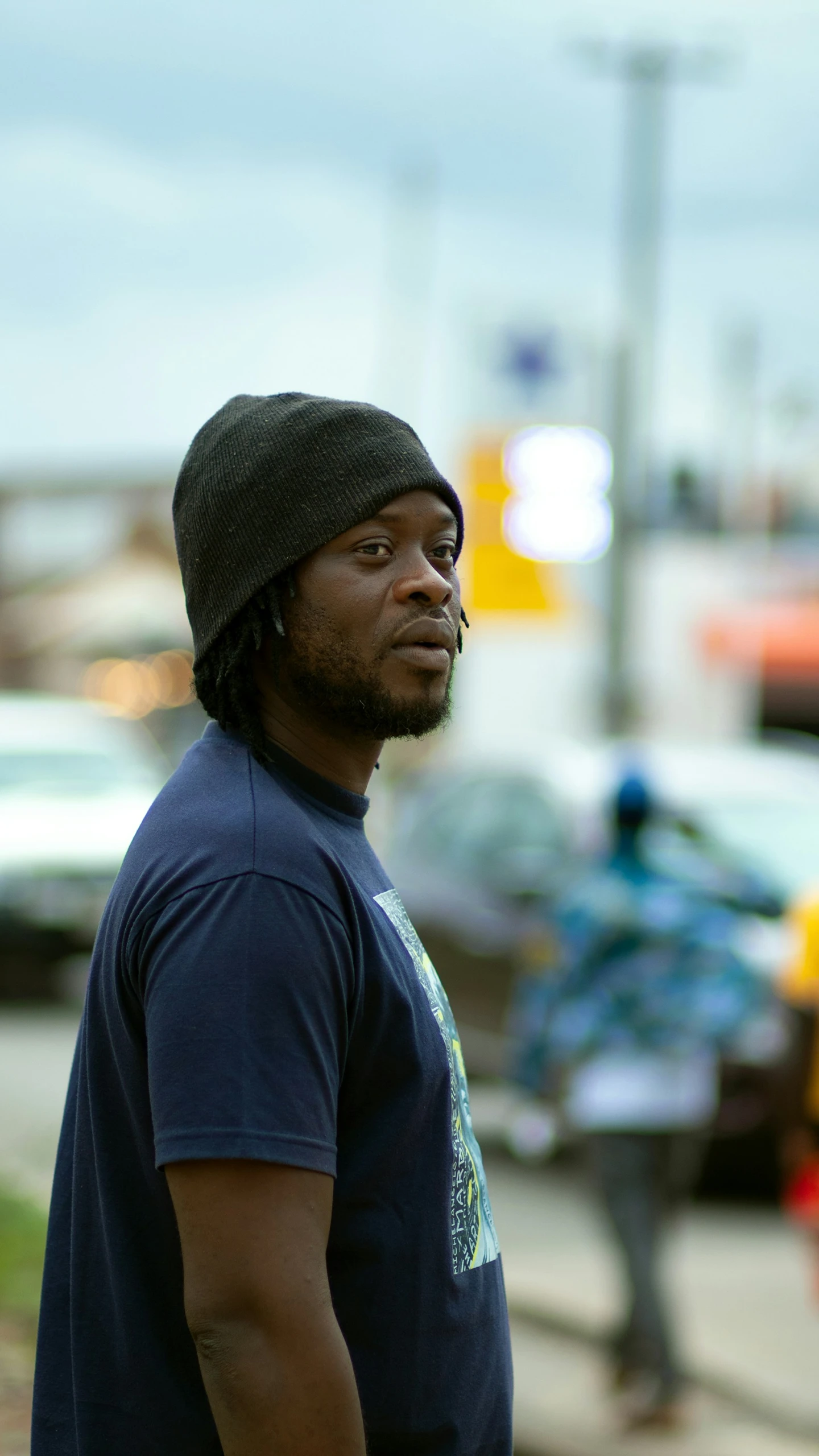 a man with a beanie standing in front of the camera