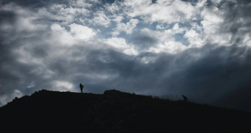 two people are standing on the top of a hill