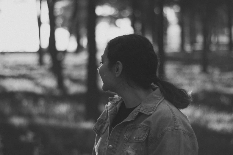 a woman is standing in the woods with headphones on