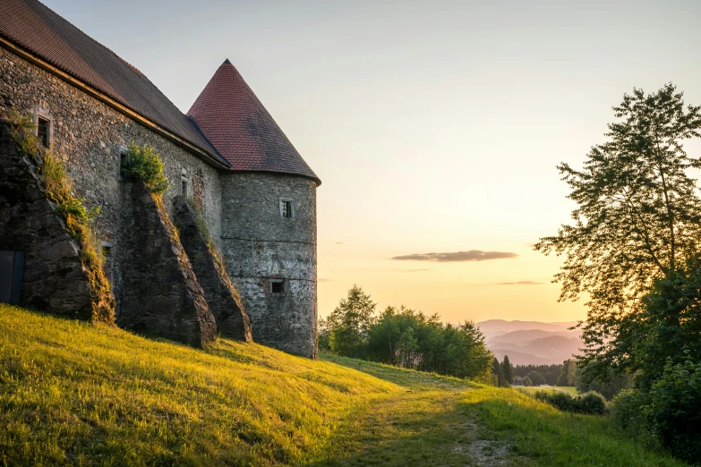 an old barn on the top of a hill