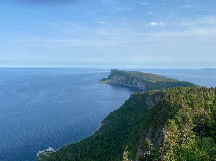 a group of hikers overlooks an island off the side of a cliff