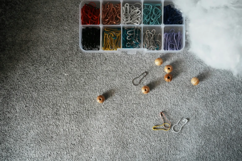 plastic container filled with various items including scissors, hooks, and beads