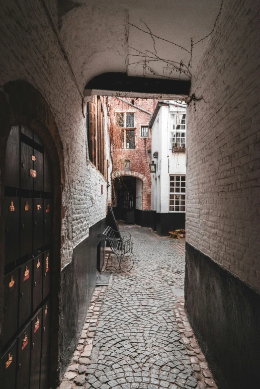 an empty cobble stone street next to a building