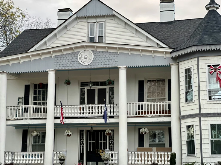 the historic home is painted white with columns and pillars