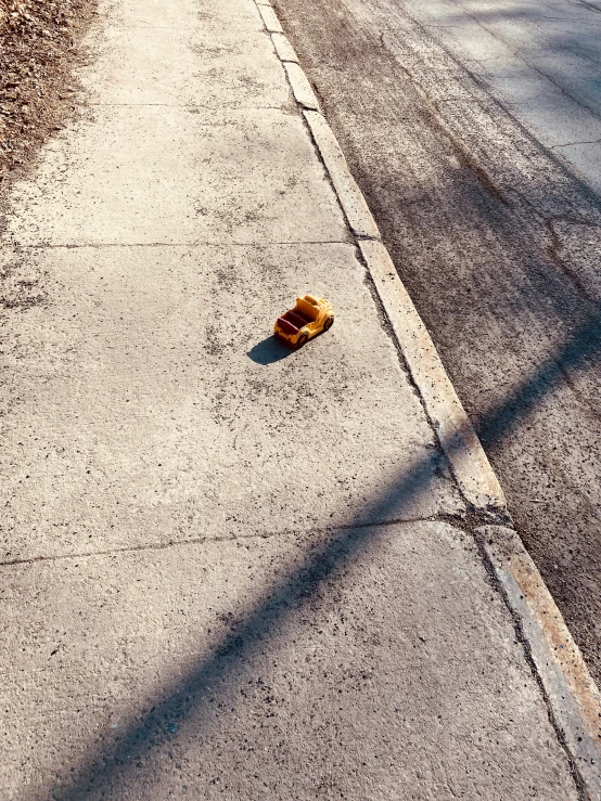 a skateboard and a yellow object on the side of the road