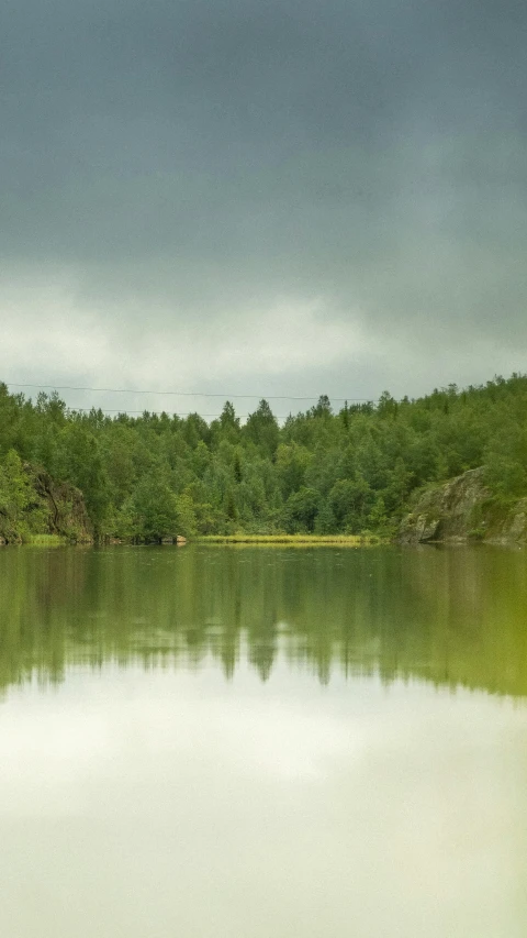 a beautiful lake with green trees on both sides
