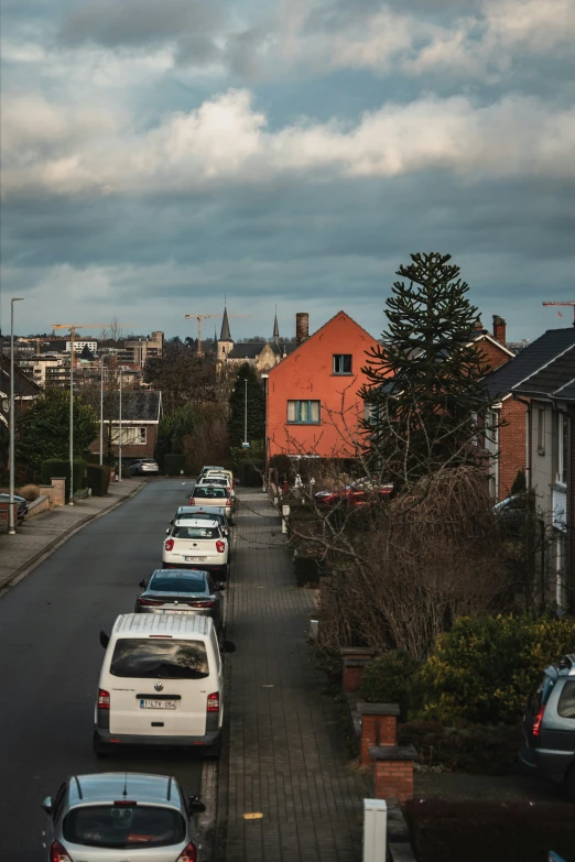 a line of parked cars in the middle of a neighborhood