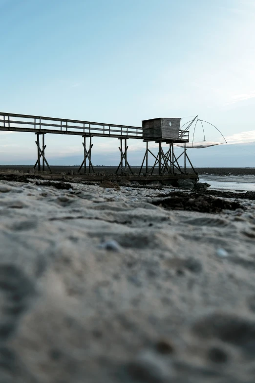 a pier sits empty on the beach near the water