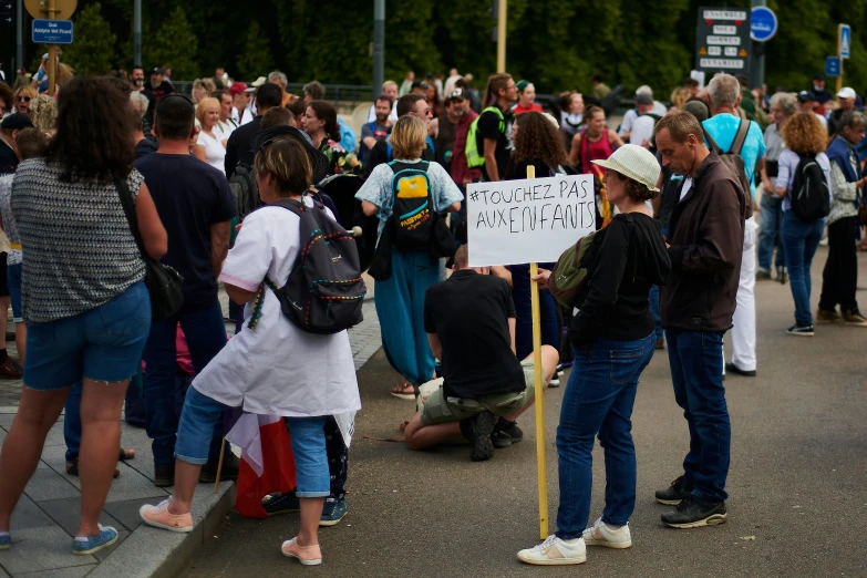 a crowd of people stand near a sign