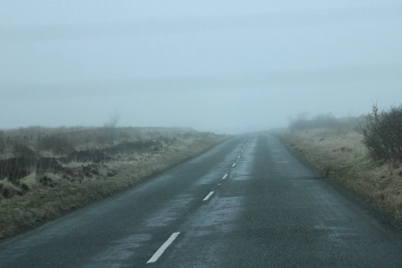 a foggy road with only two cars on it