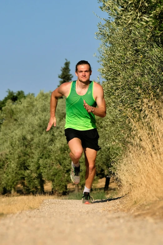 a man in green running down a road