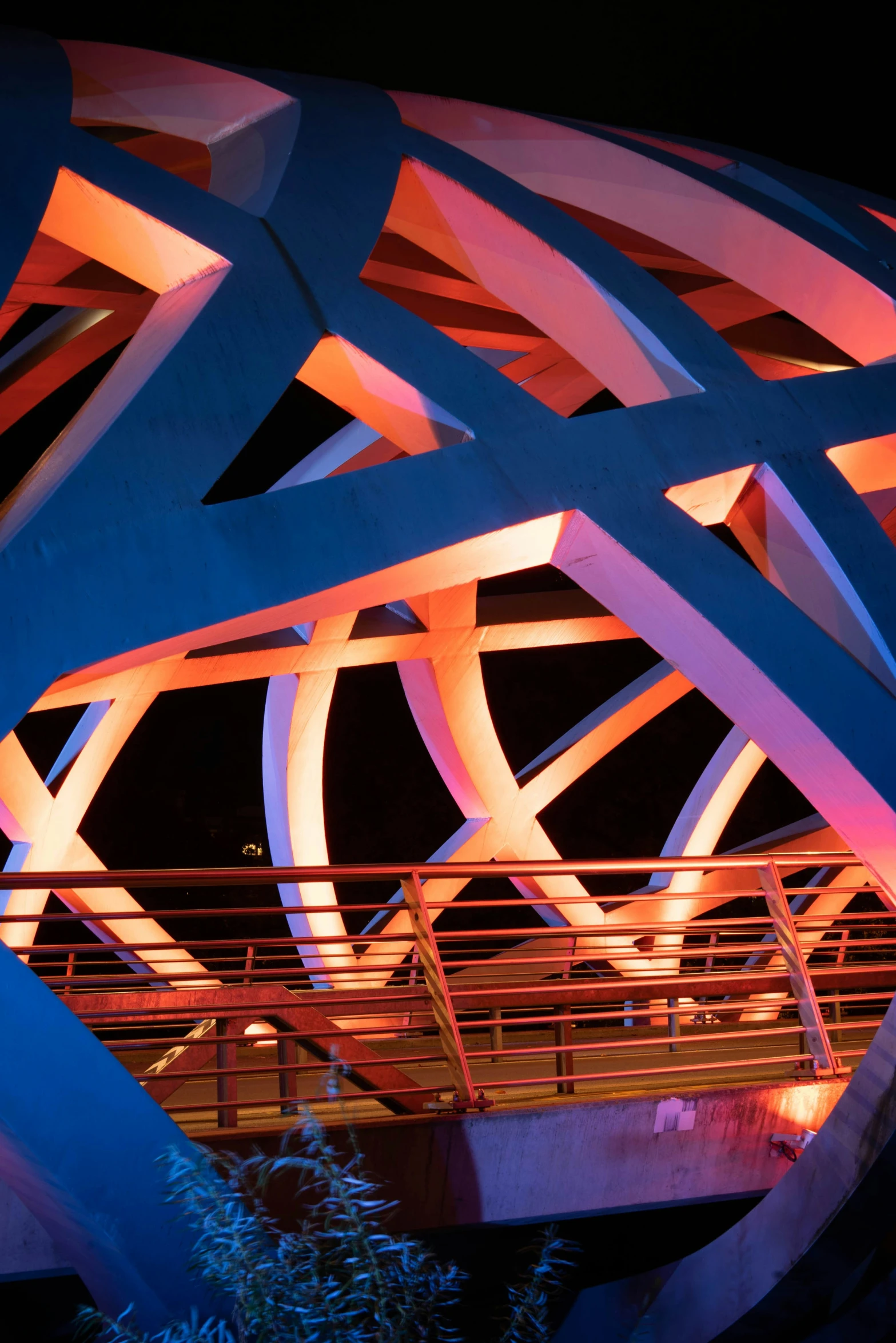 blue and red lights shine on a bridge at night