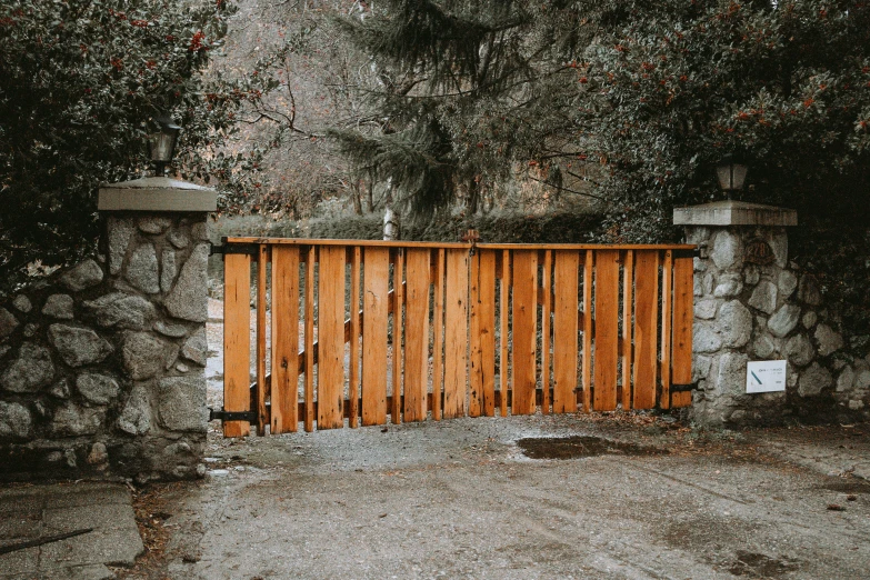 a wooden fence in front of some trees