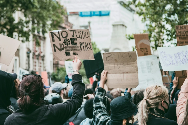 many people holding up signs on the street