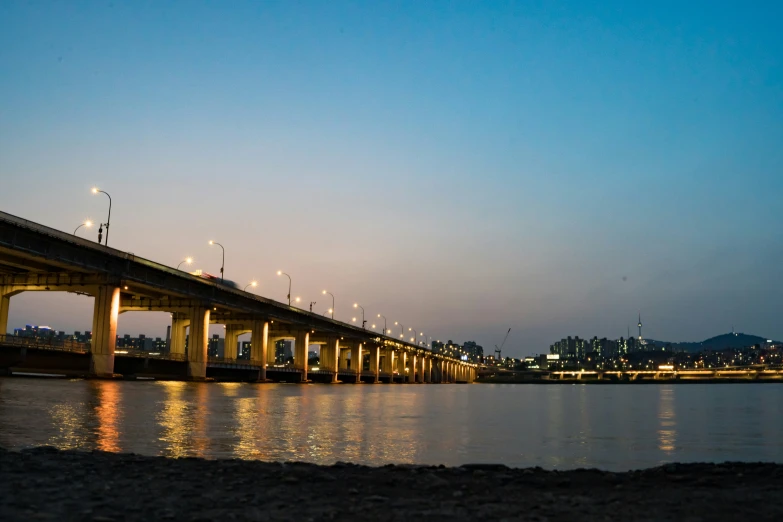 a large bridge spanning over the water at night