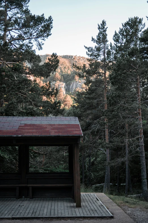 a gazebo sitting on top of a wood platform in the woods