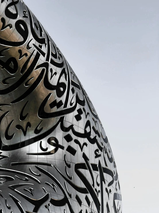 a large metal sculpture with the calligraphys on it