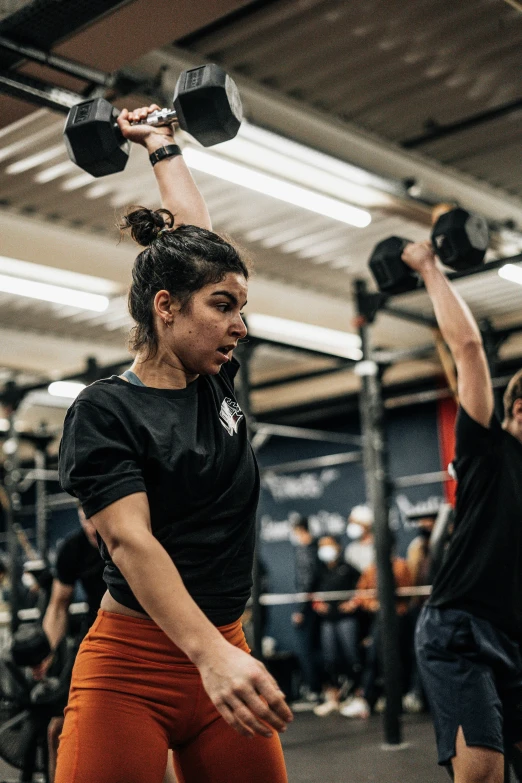 two people doing exercise in the gym with dumbs