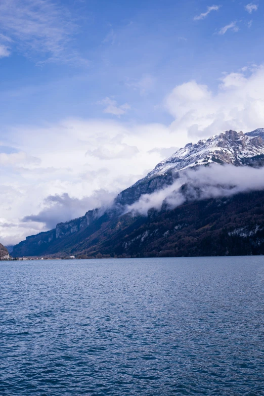 large body of water surrounded by snow covered mountains