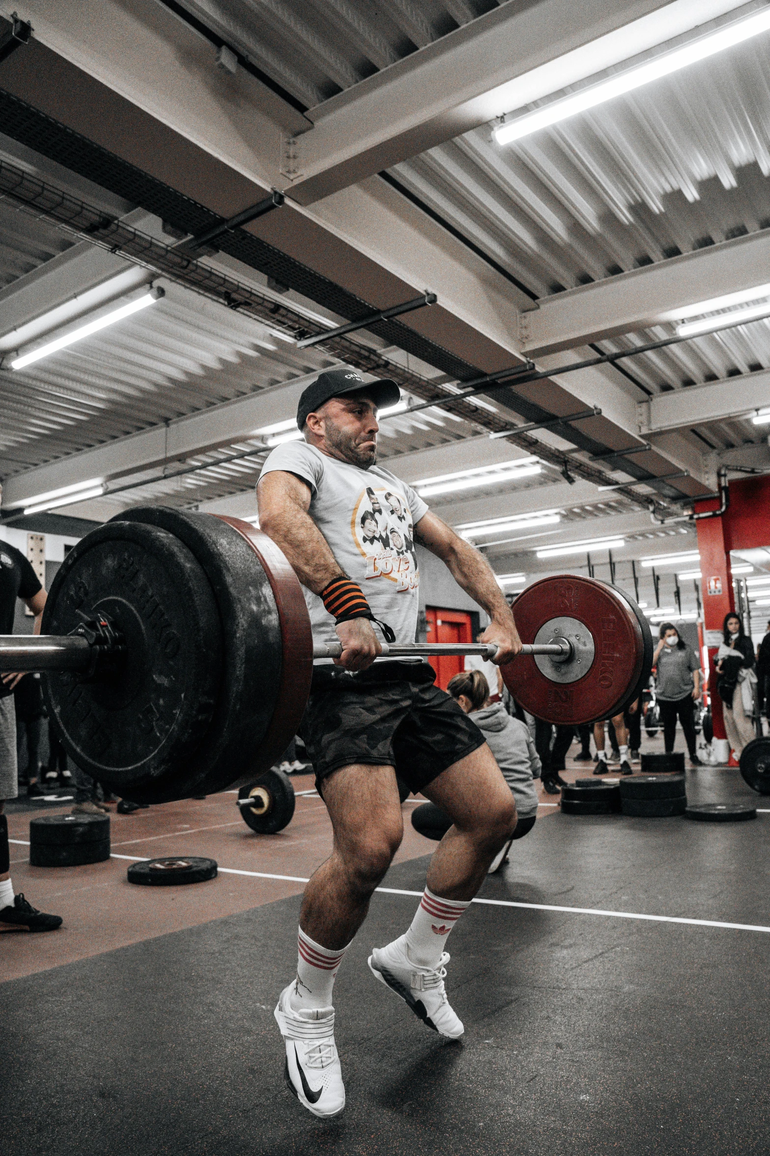 a man is holding a heavy barbell in a gym