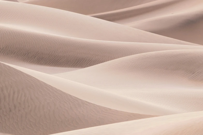 a desert with sand dunes and sand blowing up the sides