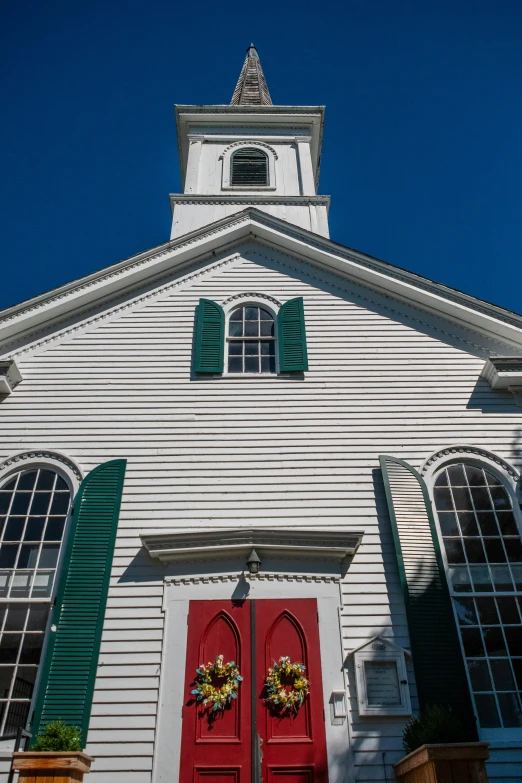 red and green shutters on a white church