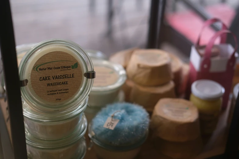 several small jars of white, orange, blue, and green essentials