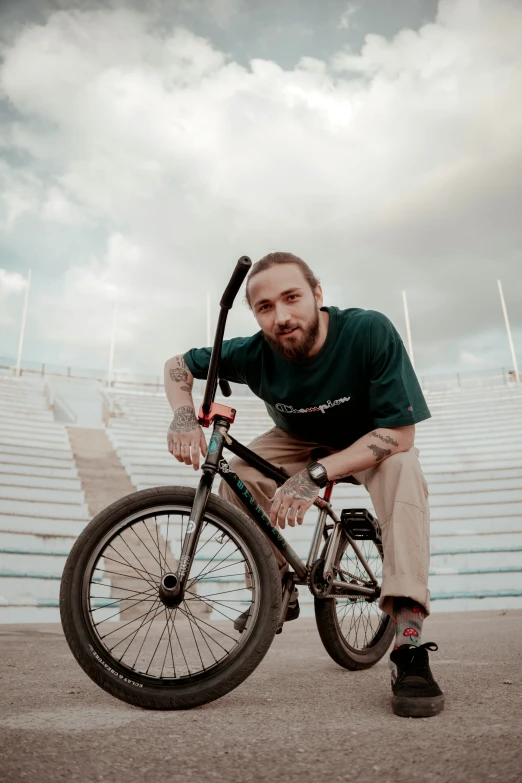 a man standing next to a bike on top of cement