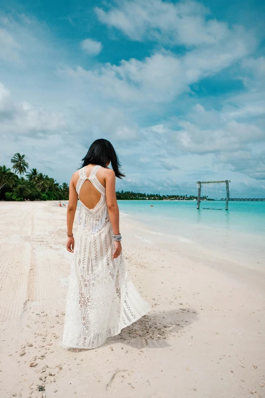 a woman is walking in the sand on the beach