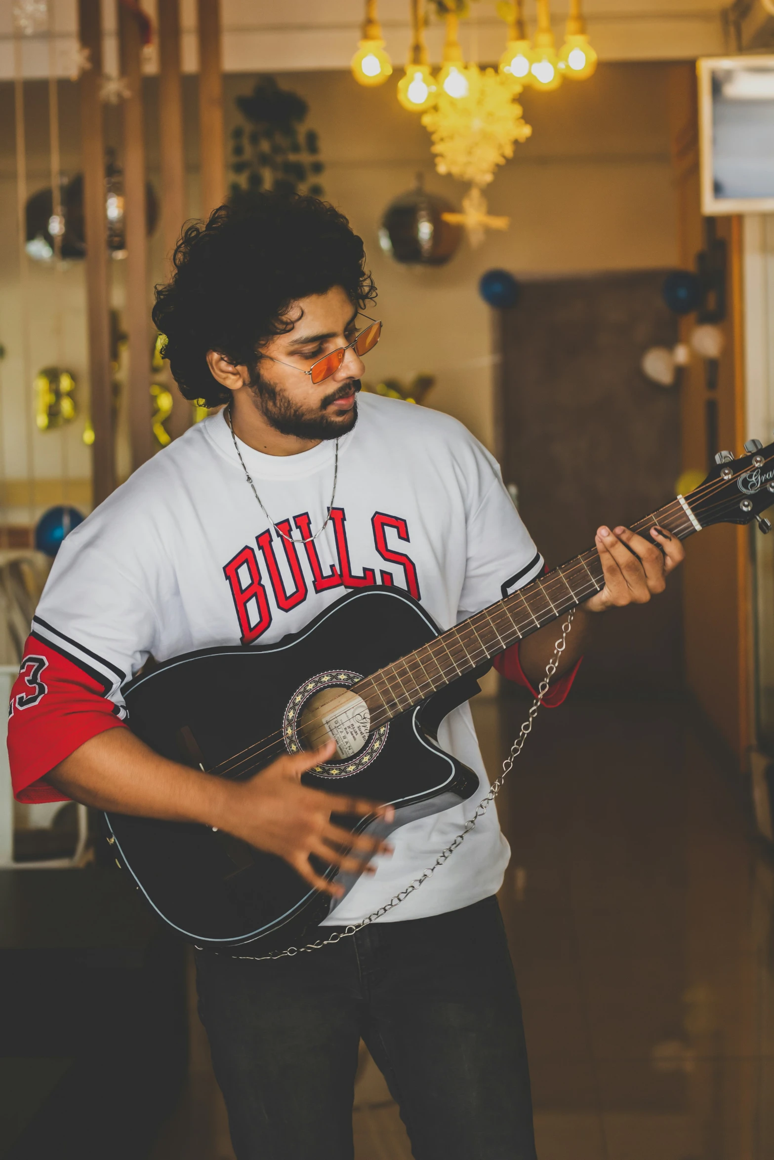 a man with glasses and beard holding a guitar