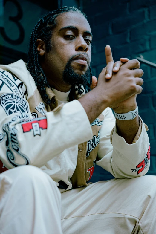 a man sitting down smoking and wearing a jacket