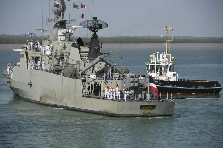 there is an old battleship with people on board in the water