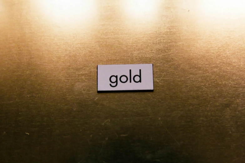 closeup s of the word gold, placed on a metal surface