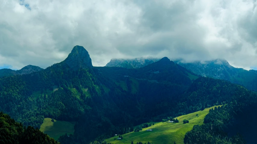 a mountain range with some green grass on top