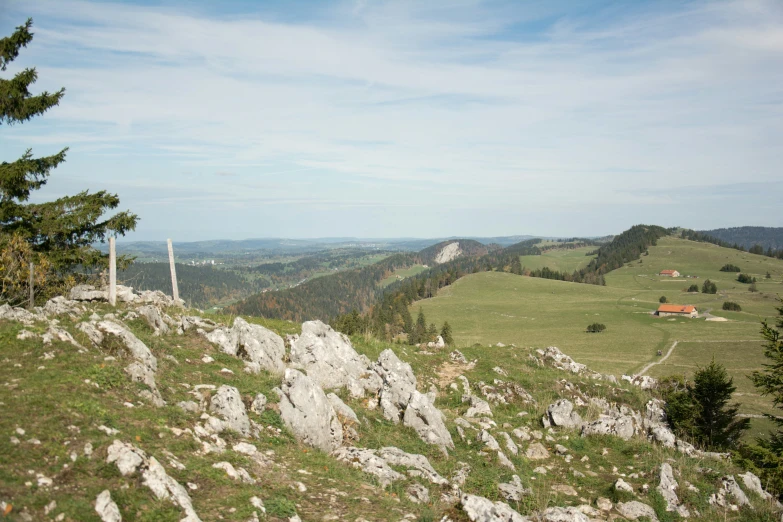 the scenic view from the peak of a mountain with hills and trees in the distance