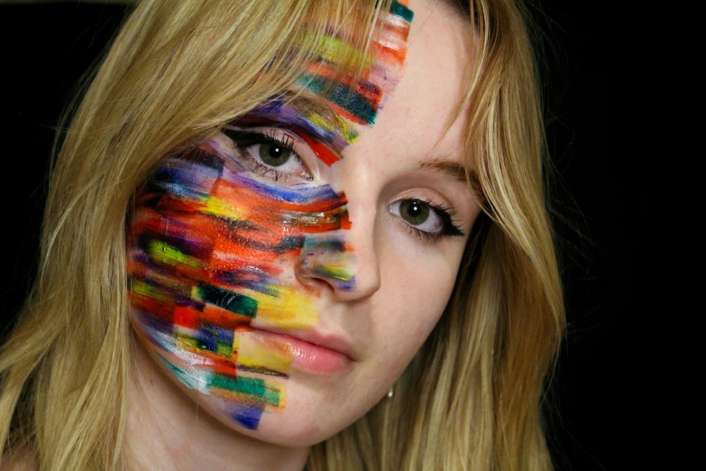 a woman is painted with various shades of multicolored paint