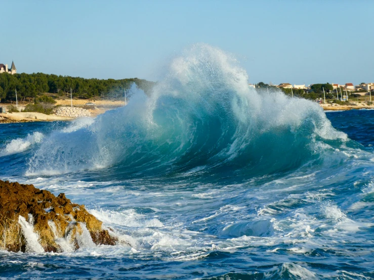 a huge wave crashing against the rocks in the ocean