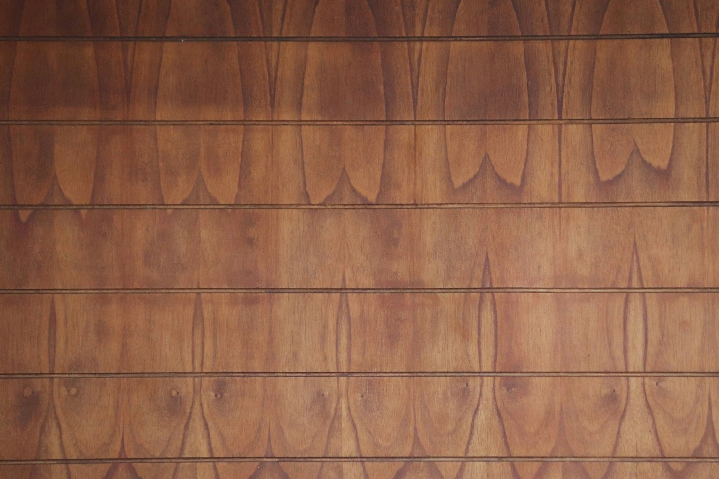 a wall with wood textured panels and a brown chair