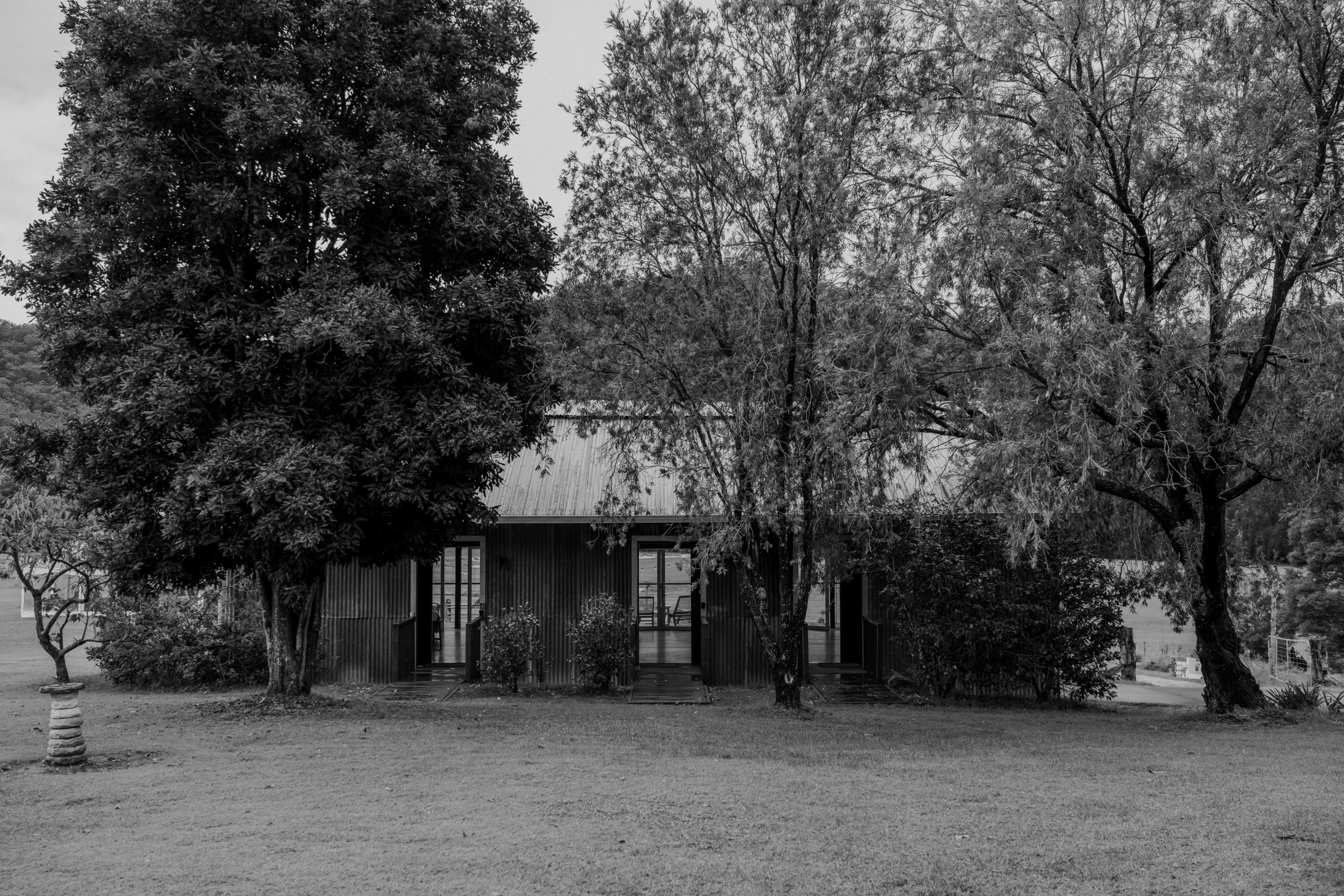 black and white po of an old building surrounded by trees