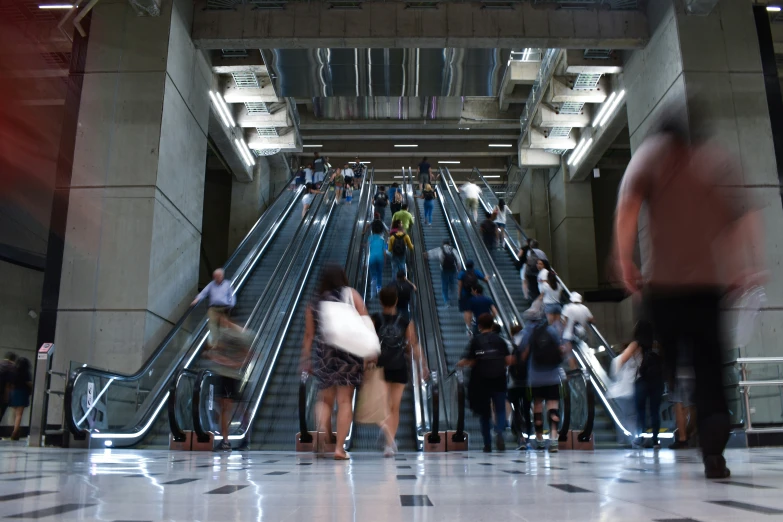 people are moving on the escalator near the stairs