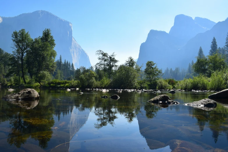 a small body of water surrounded by trees and mountains