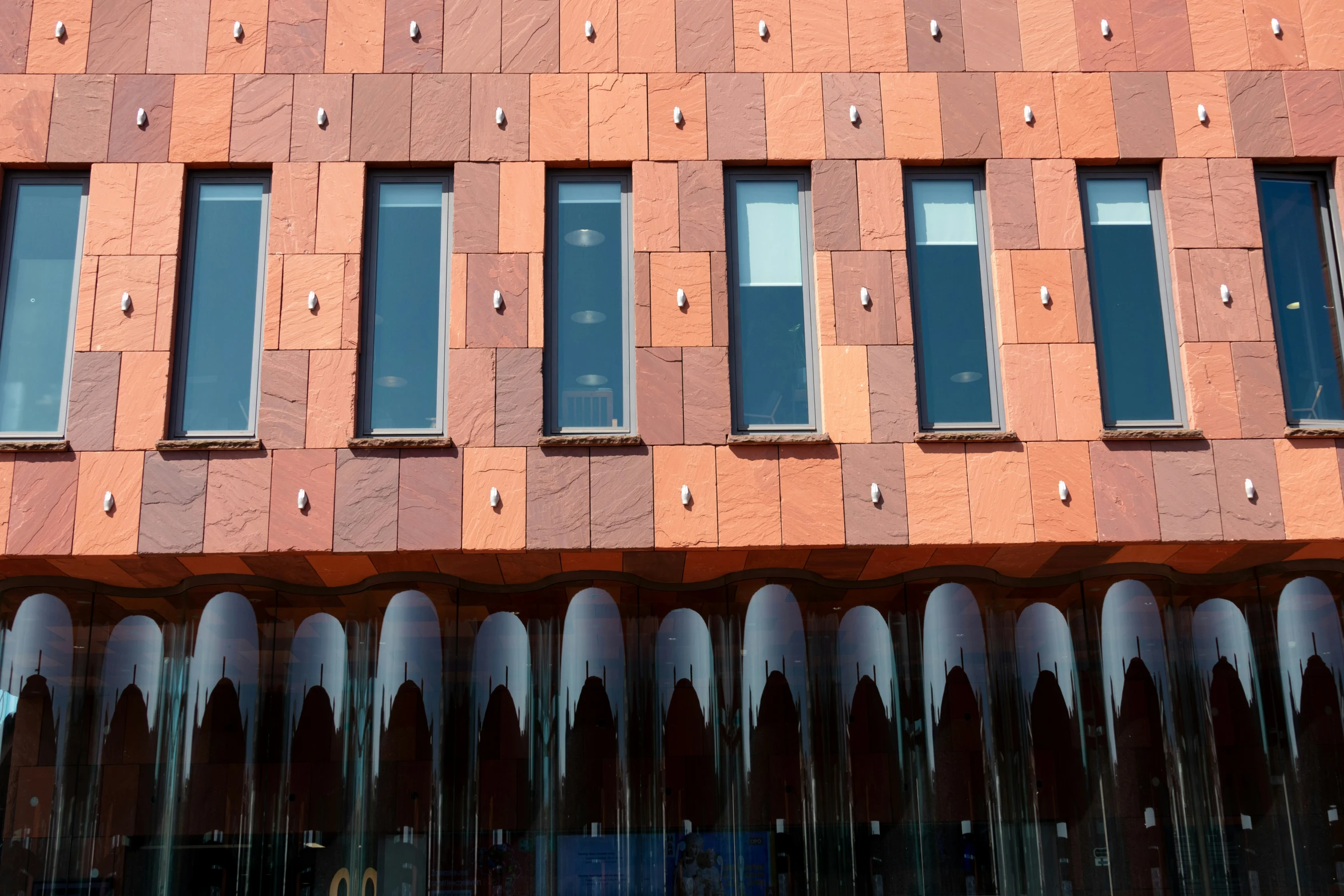 brick building with multiple windows next to tall buildings