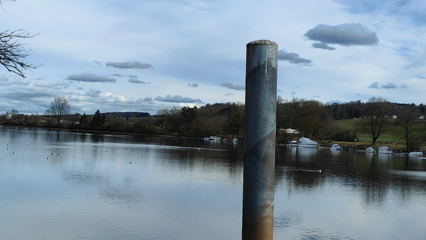 a flooded waterway with a wooden post in the middle of it