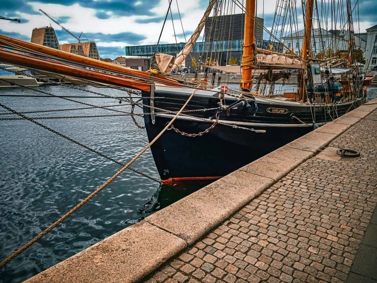 an old sailing vessel docked next to the dock