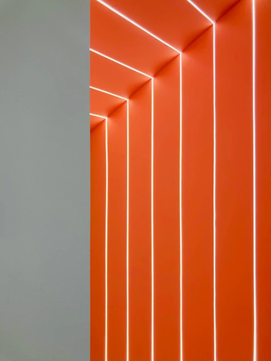 a group of orange neon lights against a white wall