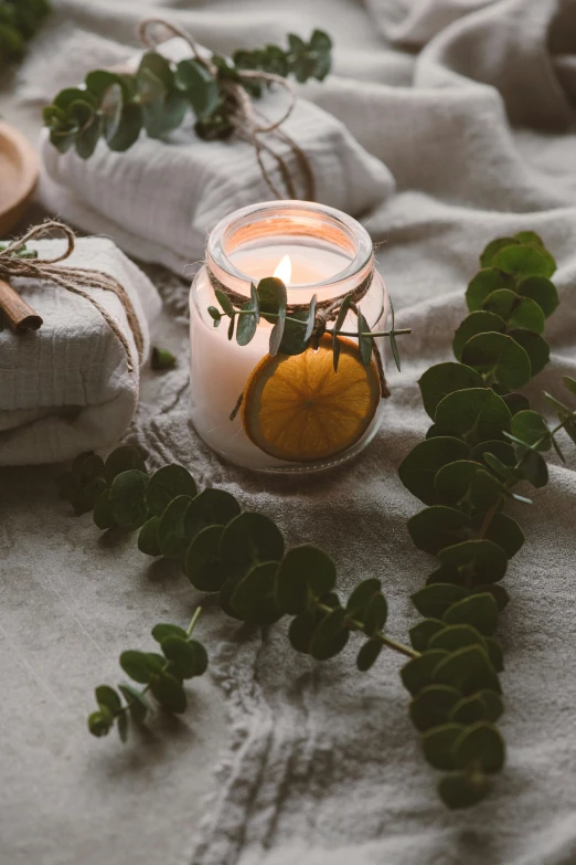 a jar filled with a orange sitting on top of a cloth covered ground