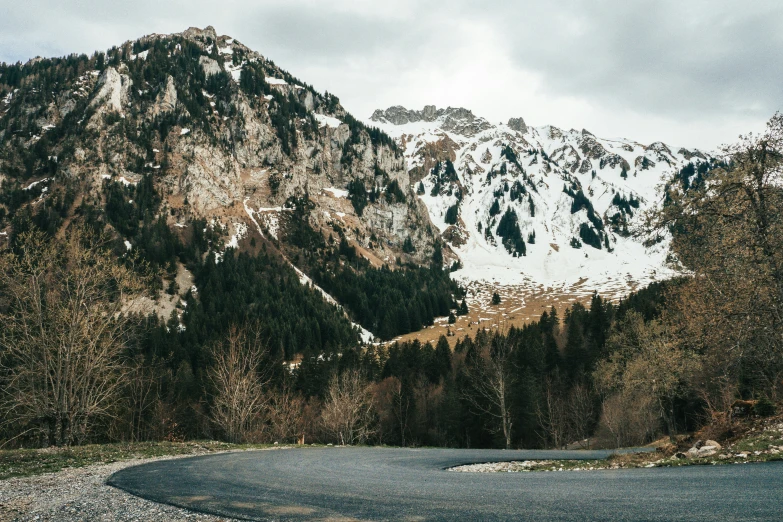 an empty paved road near a large mountains