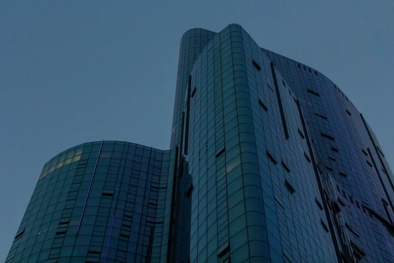 the front of a building at night, with two people walking up and down it