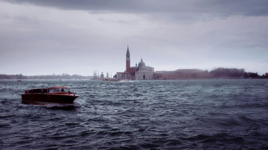 a small boat floating on the water with a church in the background