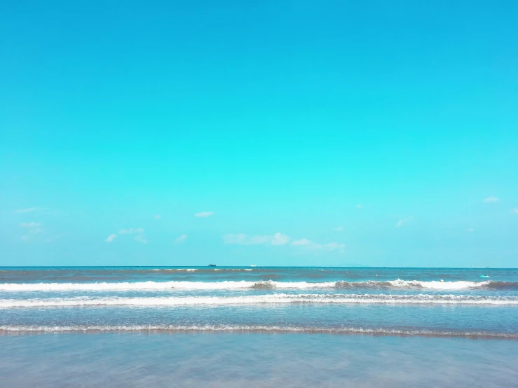 an empty beach with waves coming in to shore